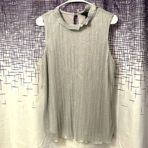Glittery sleeveless top with mock turtle neck in silver. Includes liner tank top